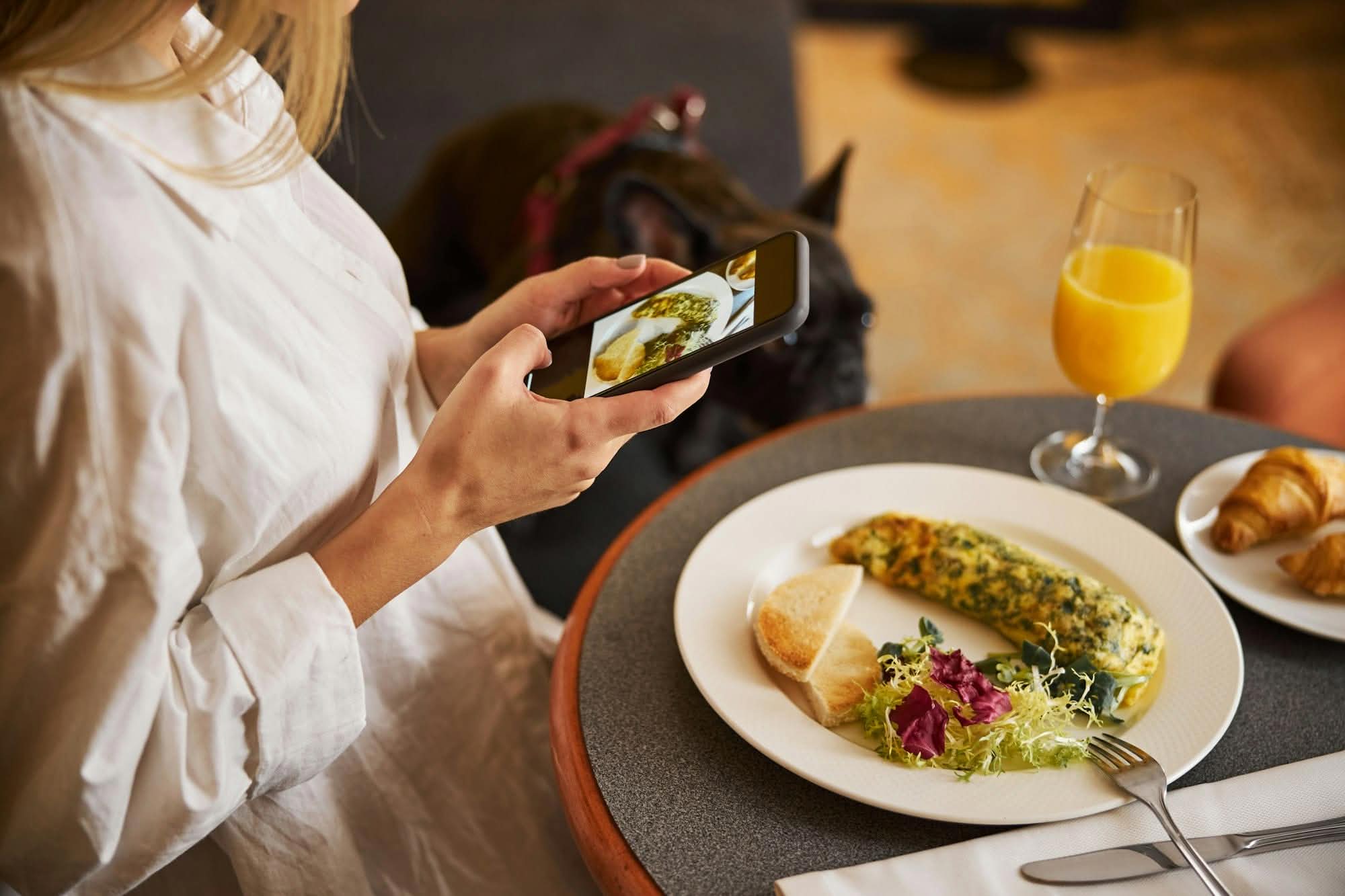 Caucasian female blogger capturing her breakfast food